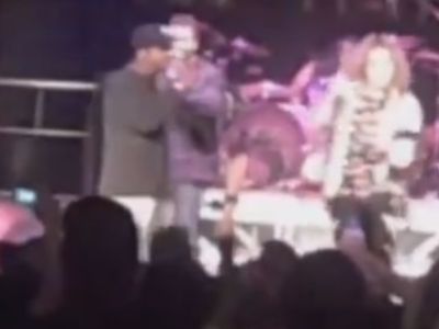 Alfonso Ribeiro is on the stage holding the mic as he speaks.